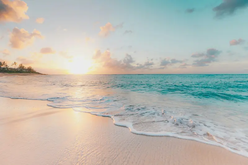 Calm turquoise water and pale sand at sunrise on a Caribbean beach